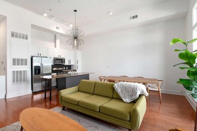 Living area featuring dark wood-type flooring, baseboards, a high ceiling, and track lighting