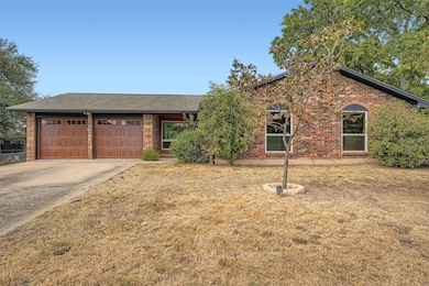 Ranch-style house with driveway, brick siding, a