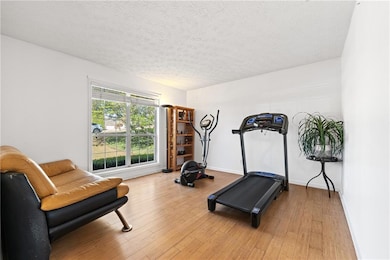 Workout room featuring baseboards, light wood-styl