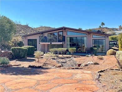Back of property with stucco siding, a balcony, and a mountain view