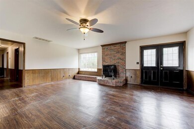 Living room wlarge windows and double doors to bac