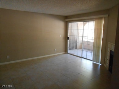 Unfurnished room featuring baseboards, a textured