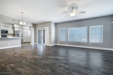 Unfurnished living room featuring a ceiling fan, d