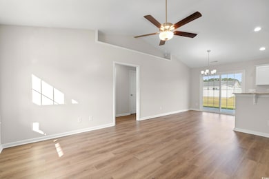 Unfurnished living room featuring light wood-style flooring, vaulted ceiling, a ceiling fan, a chandelier, and recessed lighting