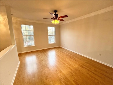 Empty room with crown molding, ceiling fan, and wo