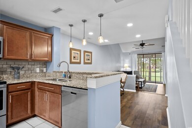 Kitchen featuring appliances with stainless steel finishes, a sink, a peninsula, brown cabinetry, and recessed lighting