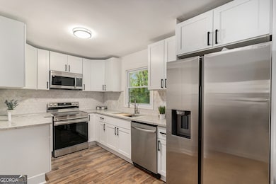 Stylish Kitchen With Stainless Steel Appliances, Granite Counters, & Tile Backsplash