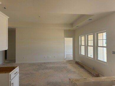 Unfurnished living room featuring baseboards and concrete flooring