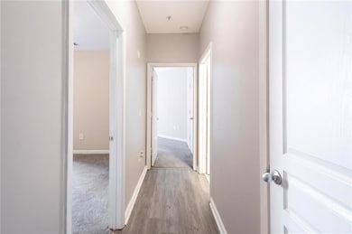 Hallway with baseboards and wood finished floors