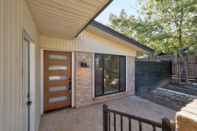 Entrance to property featuring brick siding and a patio
