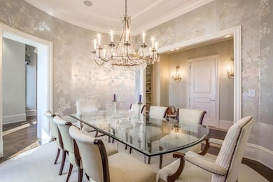 Dining area with wood-type flooring, crown molding