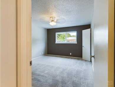 Carpeted empty room with a ceiling fan and a text