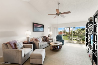 Carpeted living room featuring ceiling fan, and high vaulted ceiling