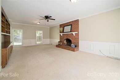 Another view of den highlighting a fireplace with 