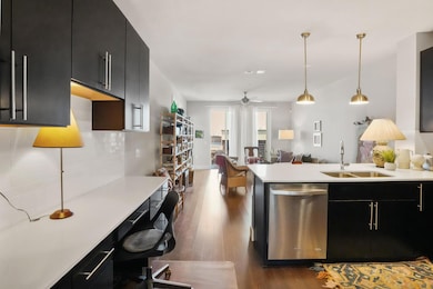 Kitchen with a sink, dark cabinets, light counter