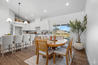Dining space featuring wood finished floors, recessed lighting, a chandelier, and vaulted ceiling