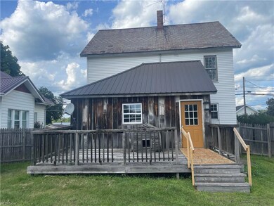 Rear view of property with a deck and a yard