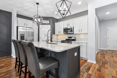 Kitchen with white cabinets, an island with sink, 