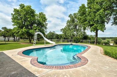 View of swimming pool with a water slide and a diving board