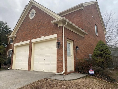 View of side of home featuring brick siding, driveway, and an attached garage