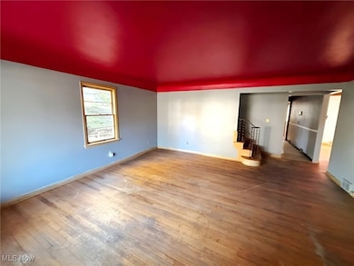 Unfurnished living room with wood-type flooring and stairs