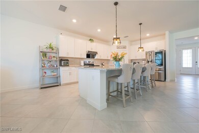 Kitchen with a breakfast bar area, white cabinetry