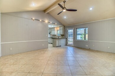 The grand family room and main living area features high, vaulted ceilings - a rare find in homes of this era, indicating it was custom built for the original owners.  The backyard views offer plenty of natural light, while ambient lighting comes from recessed lights and a contemporary ceiling fan, as well as track lighting to show off artwork.