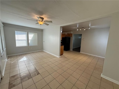 Unfurnished room featuring light tile patterned flooring and a ceiling fan