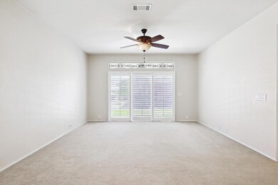 Carpeted Living room featuring ceiling fan