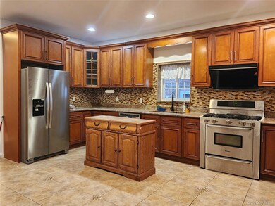 Kitchen with stainless steel appliances, brown cabinets, backsplash, and recessed lighting