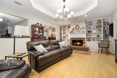 Living room with built in shelves, a raised ceilin