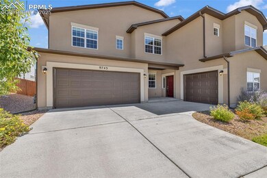 Traditional-style house with a garage, stucco siding, and driveway