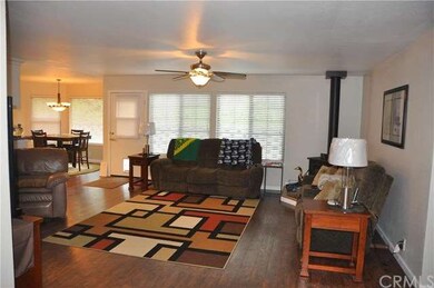 Living room with new flooring, ceiling fan and woo