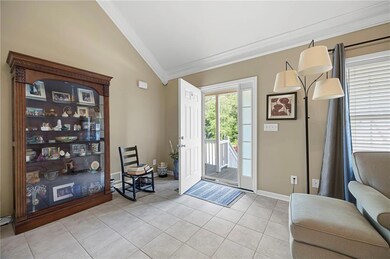 Entryway with crown molding, baseboards, light til