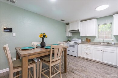 Kitchen featuring white cabinetry, light hardwood / wood-style flooring, sink, and electric stove