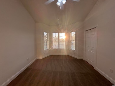 Carpeted empty room featuring lofted ceiling and c