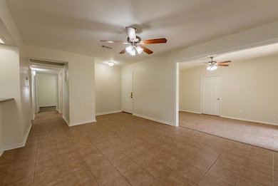 Spare room with a ceiling fan, tile patterned flo