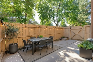 Fenced backyard featuring a gate, outdoor dining area, and a patio