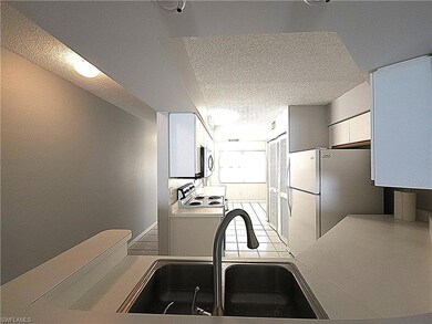 Kitchen featuring white appliances, a sink, light 