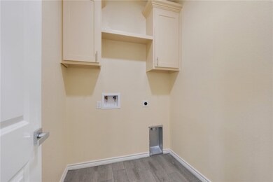 Laundry room with wood finished floors, washer hoo