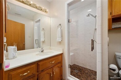 Bathroom with walk in shower, a textured ceiling, toilet, and oversized vanity