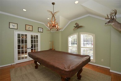Study w/french doors, wood floors, crown molding, and plantation shutters