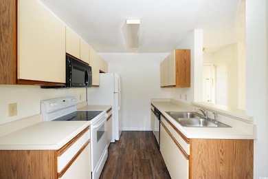 Kitchen with white range with electric stovetop, b