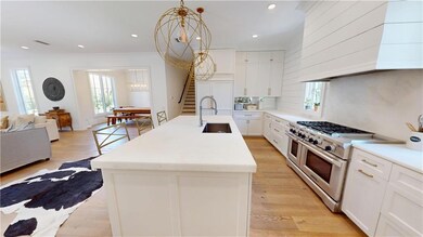 Kitchen featuring range with two ovens, a sink, custom exhaust hood, healthy amount of natural light, and recessed lighting