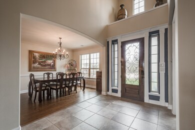 Large two-story foyer features recently added custom iron scroll work on front door!