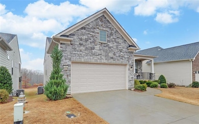 View of front of property with central AC and a ga