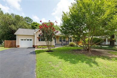 View of front of home with a porch, a garage, and a front lawn
