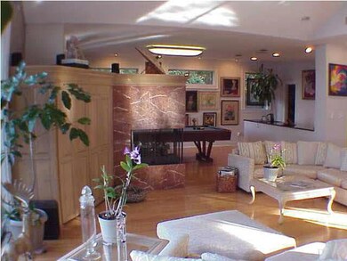 This home is designed for living. Here you see the 3-sided fireplace wing separating the living room from the recreation room and the bar separating the kitchen from the pool table. Custom lighting abounds everywhere!