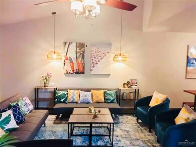 Living room with ceiling fan with notable chandelier and vaulted ceiling