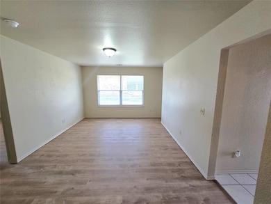 Spare room featuring baseboards, a textured ceilin
